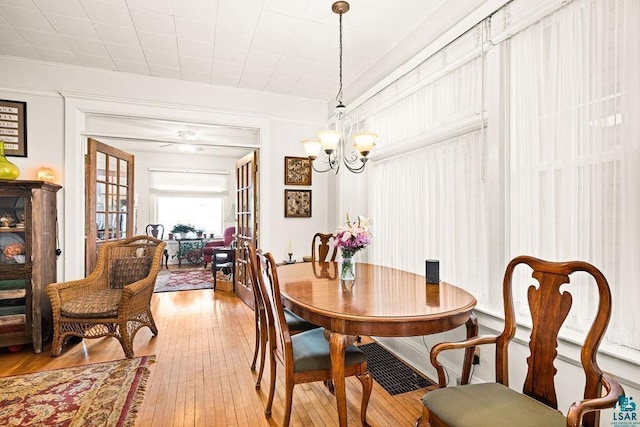 dining space featuring light wood-style floors, a chandelier, and crown molding