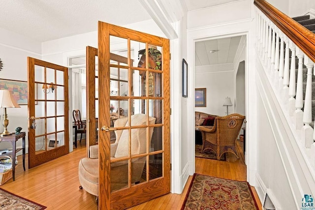 interior space with light wood-style floors, stairway, and french doors