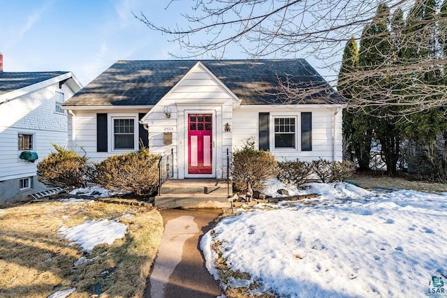 bungalow-style home with roof with shingles