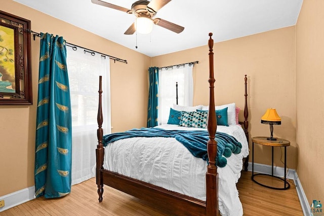 bedroom featuring a ceiling fan, baseboards, and wood finished floors