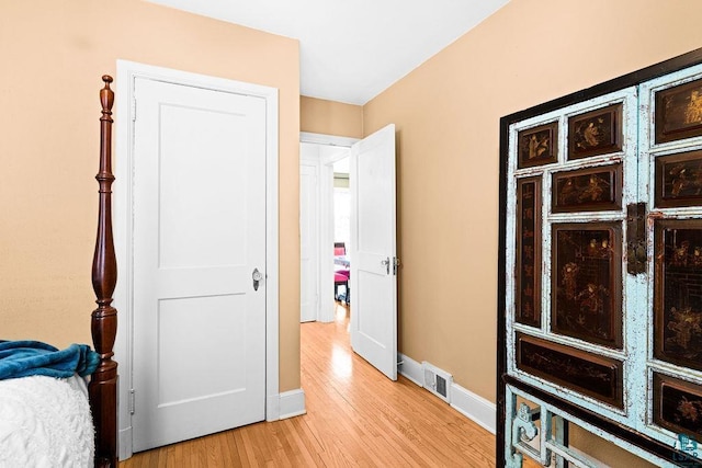 bedroom with baseboards, visible vents, and light wood-style floors