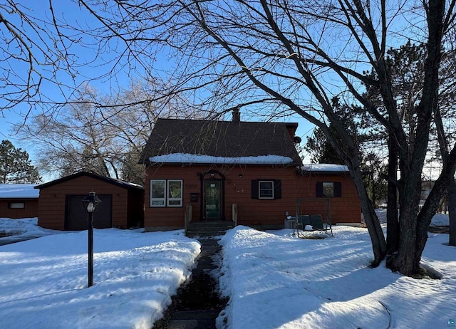 chalet / cabin featuring a garage, a shed, and an outbuilding