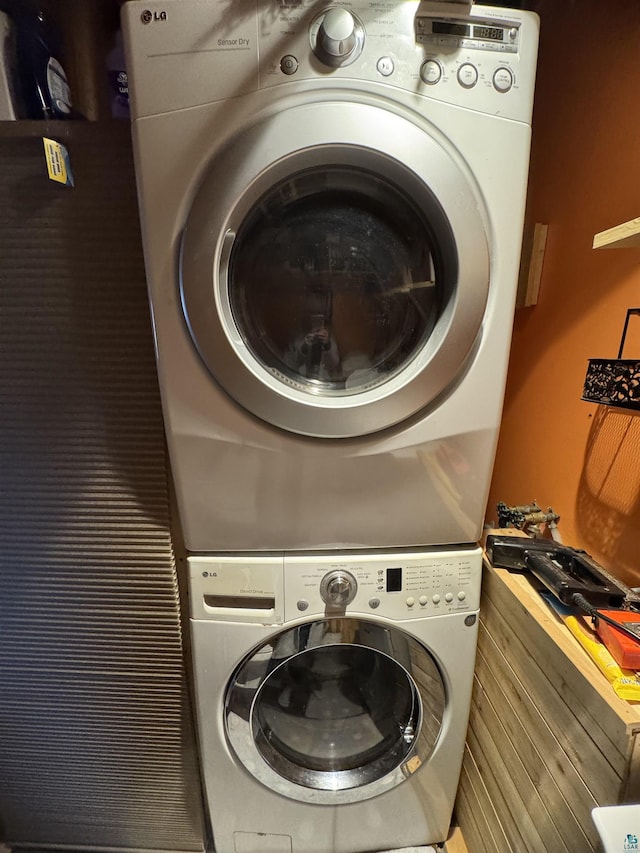 clothes washing area featuring stacked washer / drying machine and laundry area