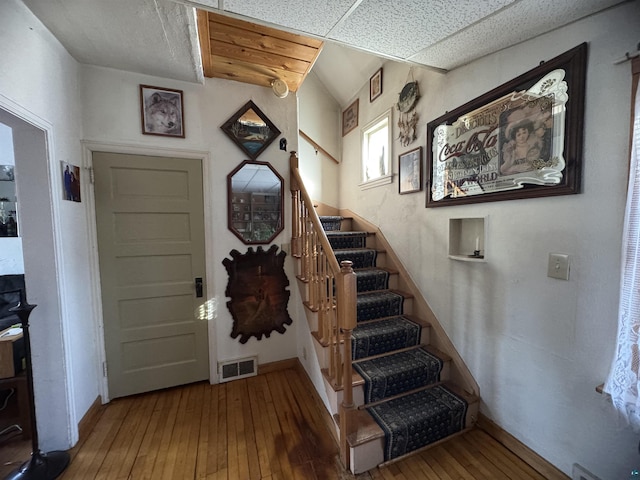 foyer with visible vents, stairway, baseboards, and hardwood / wood-style flooring