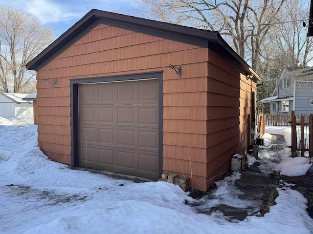 snow covered garage with a garage