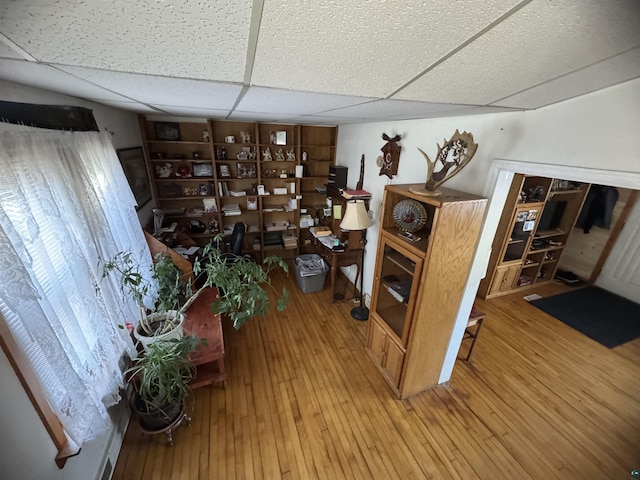 interior space with light wood-type flooring and a paneled ceiling