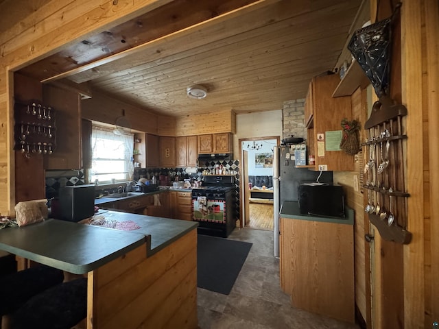 kitchen with black gas range oven, wooden ceiling, dark countertops, brown cabinets, and a peninsula