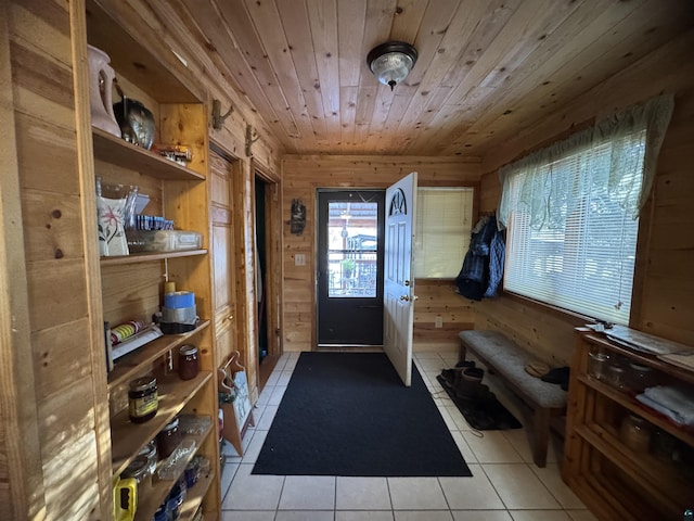 mudroom featuring wooden ceiling, wooden walls, and light tile patterned floors