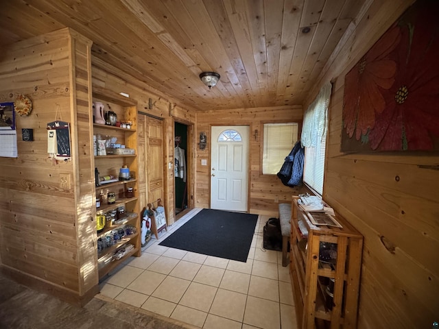 doorway with wood ceiling, wooden walls, and light tile patterned floors