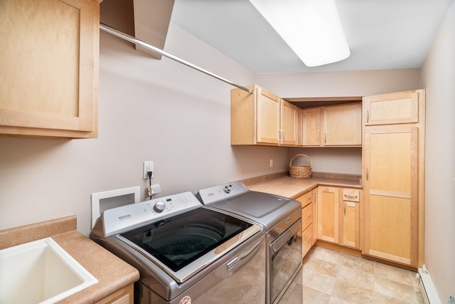 clothes washing area featuring cabinet space, a baseboard heating unit, a sink, and washing machine and clothes dryer