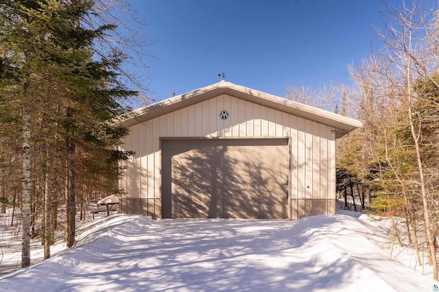 snow covered garage featuring a detached garage