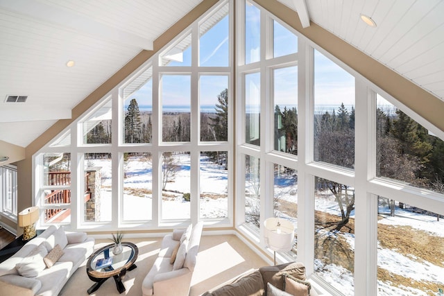 sunroom featuring lofted ceiling with beams, a healthy amount of sunlight, and visible vents