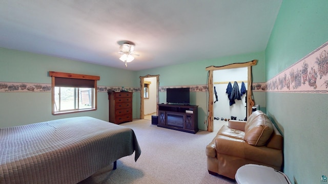 carpeted bedroom featuring a walk in closet