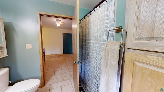 full bath with a shower with shower curtain, tile patterned floors, and toilet