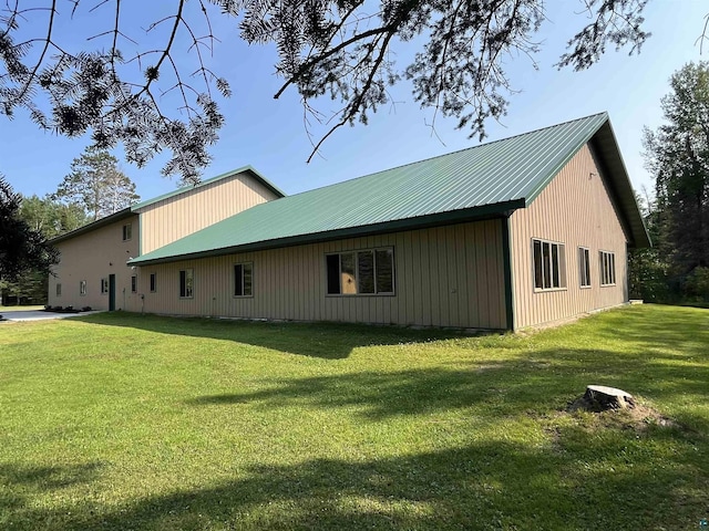 view of side of home with metal roof and a yard