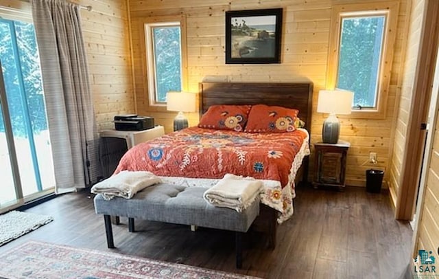 bedroom with wood walls and wood finished floors