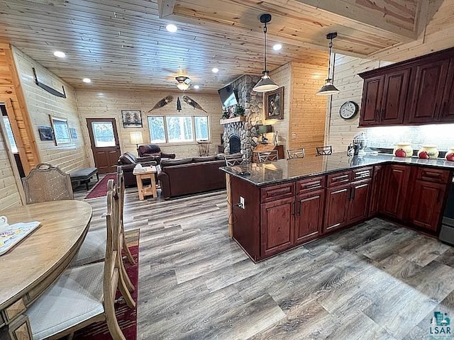 kitchen featuring open floor plan, a peninsula, wooden ceiling, and wood finished floors