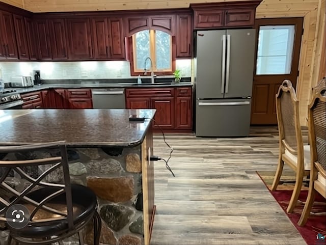 kitchen featuring dark countertops, appliances with stainless steel finishes, dark brown cabinets, and a sink