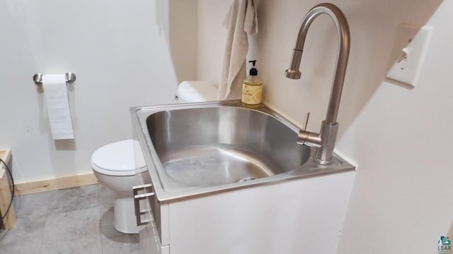 interior details with toilet, vanity, and baseboards