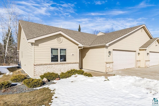 ranch-style house with a garage, driveway, brick siding, and a shingled roof