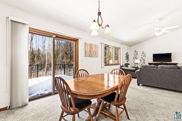 carpeted dining room featuring lofted ceiling and ceiling fan with notable chandelier