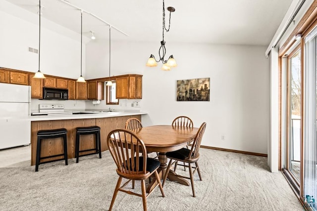 dining space featuring high vaulted ceiling, visible vents, light colored carpet, a chandelier, and baseboards