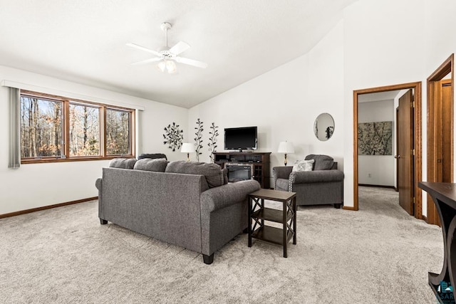 living area featuring baseboards, a ceiling fan, and light colored carpet