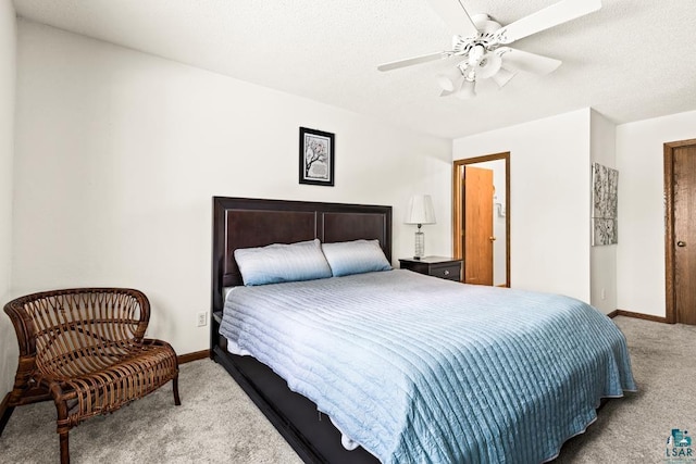 carpeted bedroom featuring a ceiling fan, a textured ceiling, and baseboards