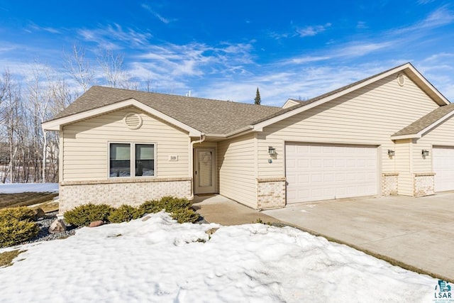 single story home with a garage, driveway, brick siding, and a shingled roof