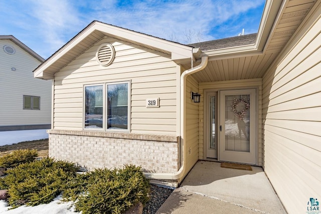 doorway to property with brick siding