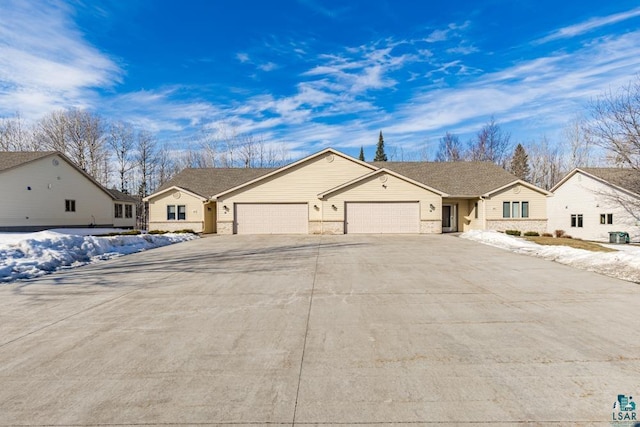 ranch-style house featuring a garage, concrete driveway, and brick siding