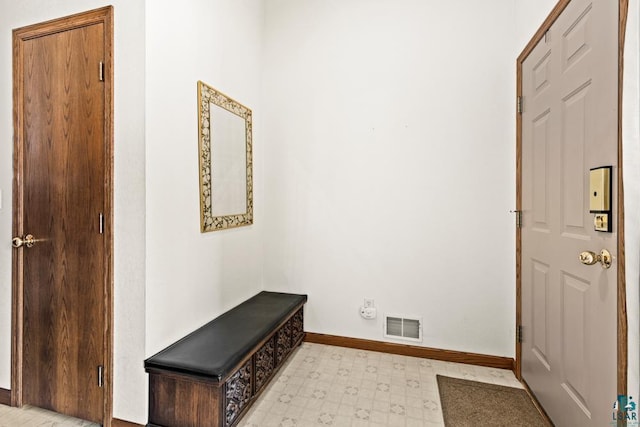 foyer with light floors, baseboards, and visible vents