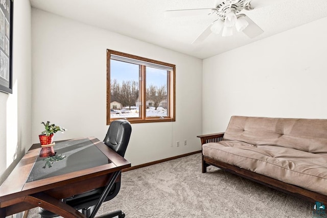 carpeted home office with a ceiling fan and baseboards