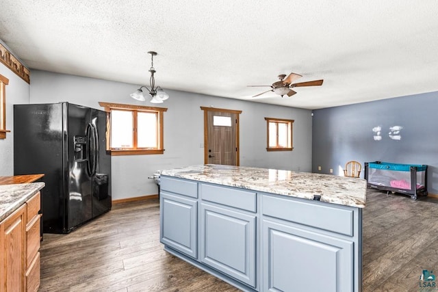 kitchen featuring dark wood-style floors, black refrigerator with ice dispenser, a textured ceiling, and a wealth of natural light