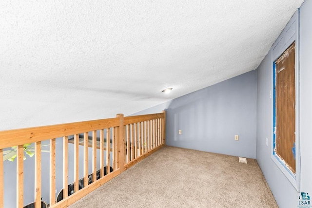 carpeted empty room with a textured ceiling