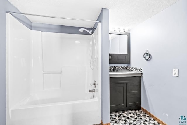 full bathroom with bathtub / shower combination, vanity, baseboards, and a textured ceiling