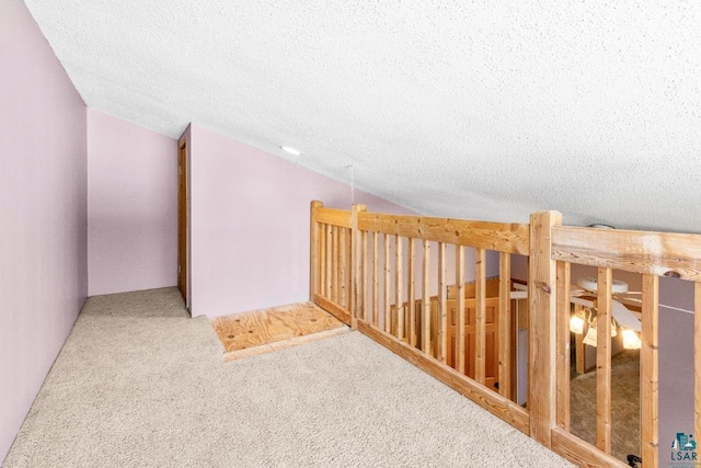 bonus room featuring vaulted ceiling, carpet floors, and a textured ceiling