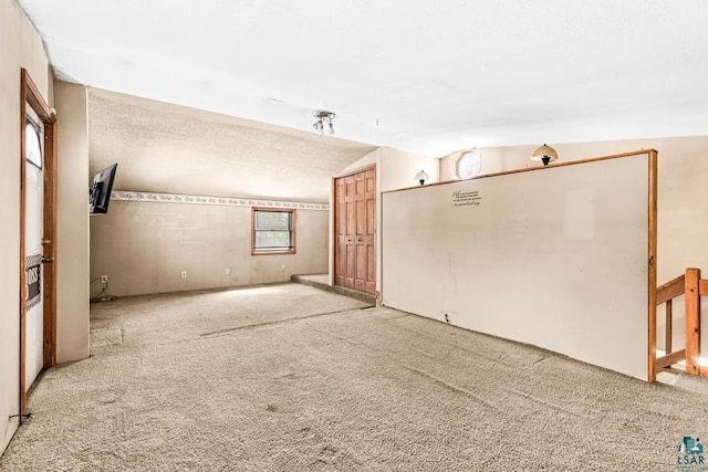 carpeted spare room with lofted ceiling and a textured ceiling