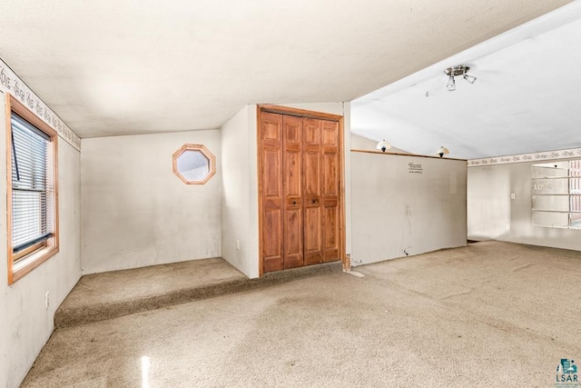 carpeted spare room with lofted ceiling