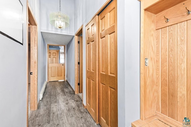 hallway with a chandelier and wood finished floors