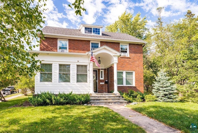 traditional style home featuring brick siding and a front yard