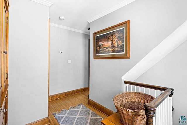 corridor with baseboards, ornamental molding, and wood finished floors