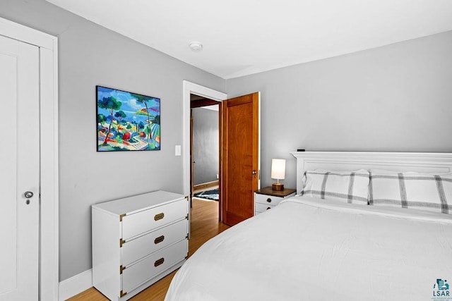 bedroom with light wood-style flooring and baseboards