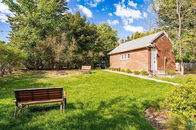 view of yard with an outdoor fire pit and fence