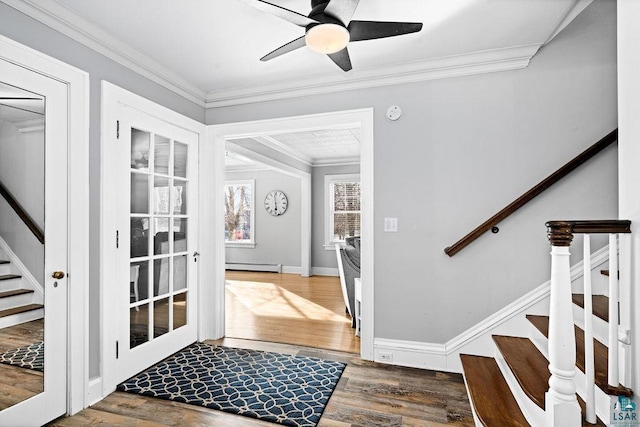 entryway featuring a baseboard radiator, wood finished floors, a ceiling fan, stairs, and crown molding