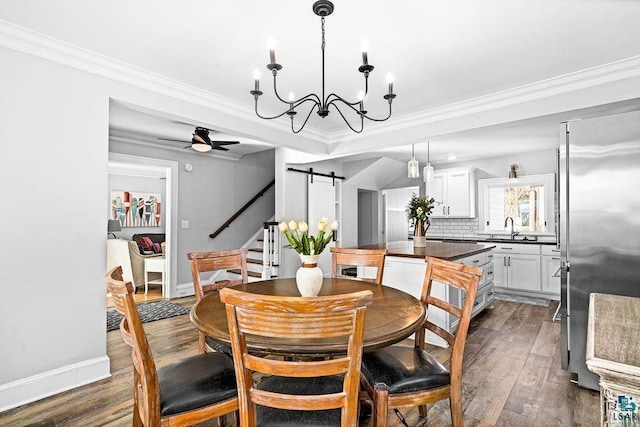 dining area with a barn door, a ceiling fan, baseboards, dark wood-style floors, and crown molding