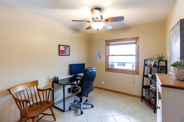 office space featuring a ceiling fan, light tile patterned flooring, a textured ceiling, and baseboards