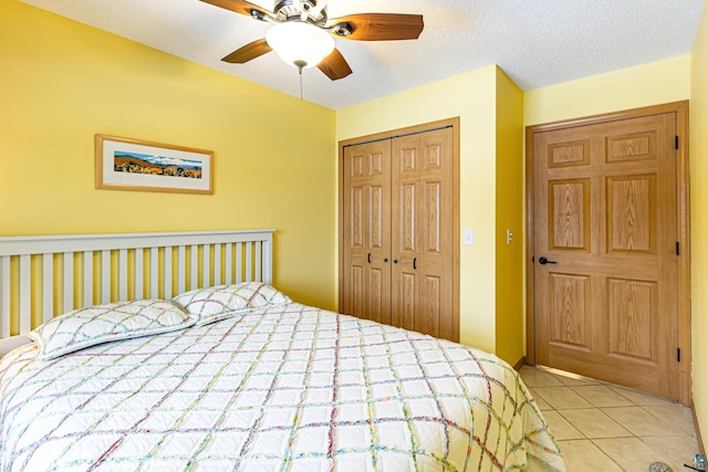 bedroom with ceiling fan, a textured ceiling, a closet, and tile patterned floors