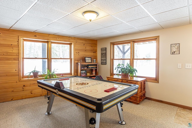 game room with wood walls, baseboards, and a drop ceiling