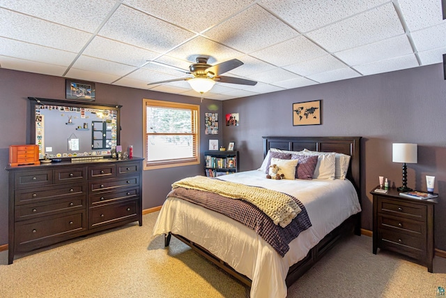 bedroom featuring a paneled ceiling, ceiling fan, baseboards, and light colored carpet